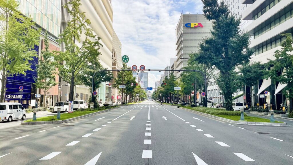 昼間の御堂筋の街並みを走り抜けるランナーのイメージ。大阪から未来へ踏み出す一歩を象徴する明るい都市風景。