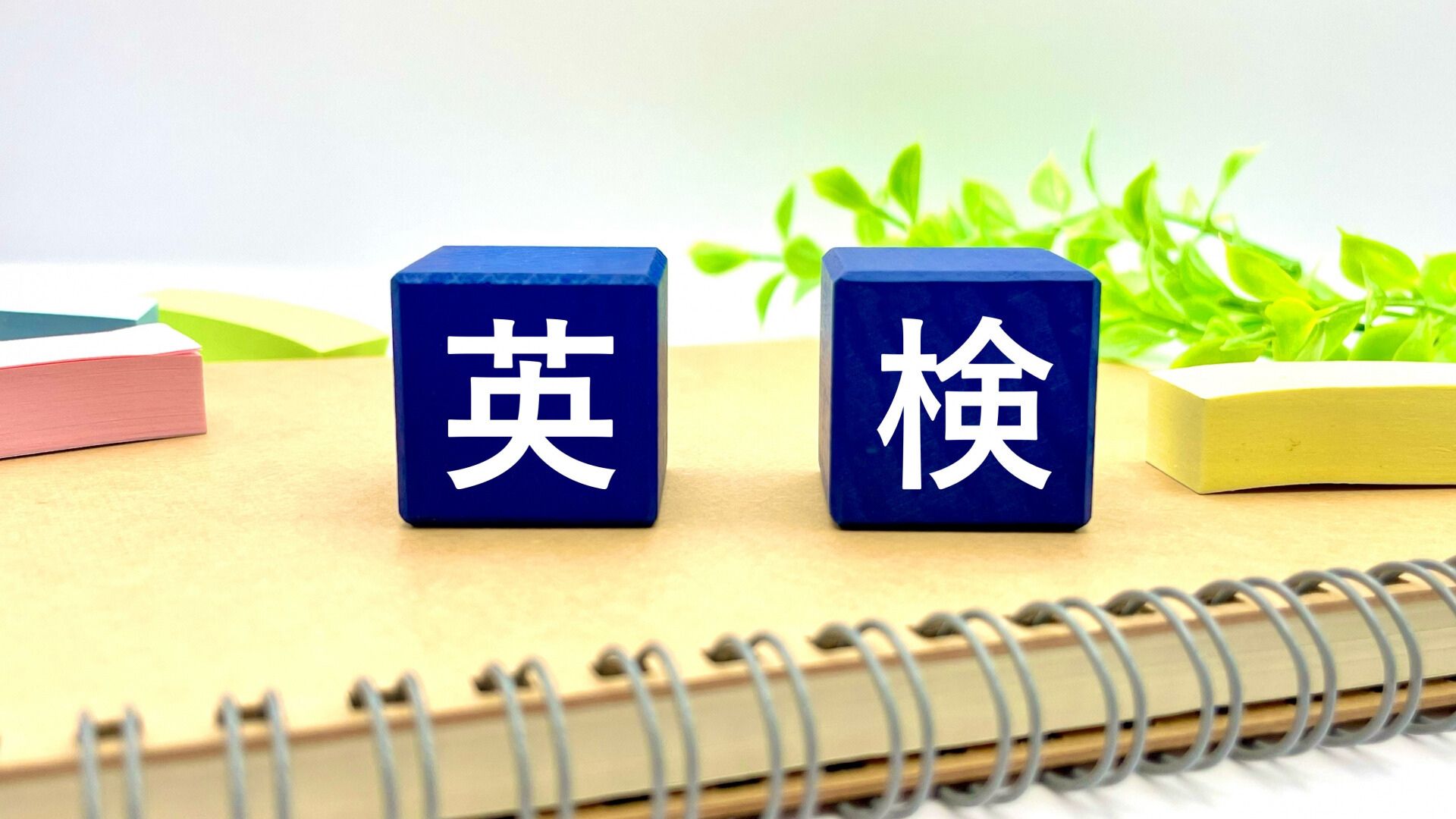 ノートの上に英検と書かれた積み木が並んでいる様子。英検1級要約問題の0点問題を扱う記事のイメージ画像