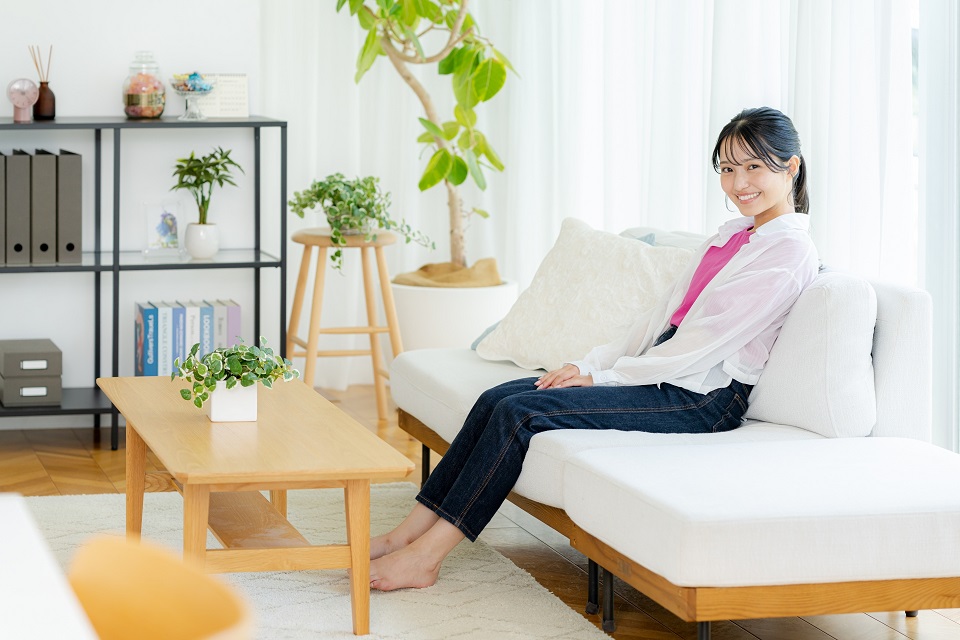 自宅のリビングで座ってくつろぐ女性の様子