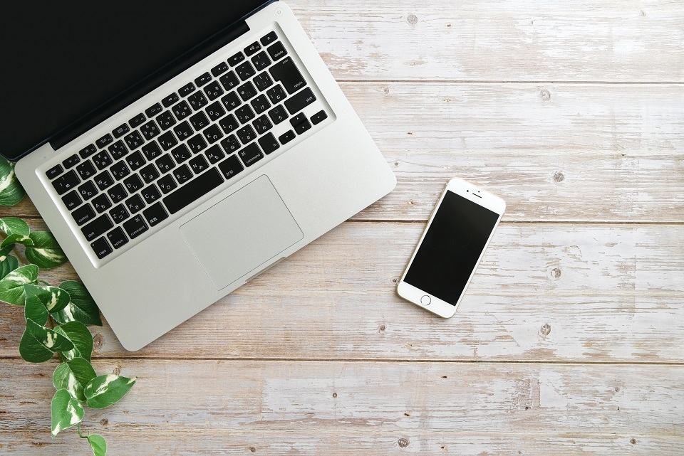 パソコンと画面をオフにしたスマートフォンが並ぶ、思考を振り返る時間をイメージした写真