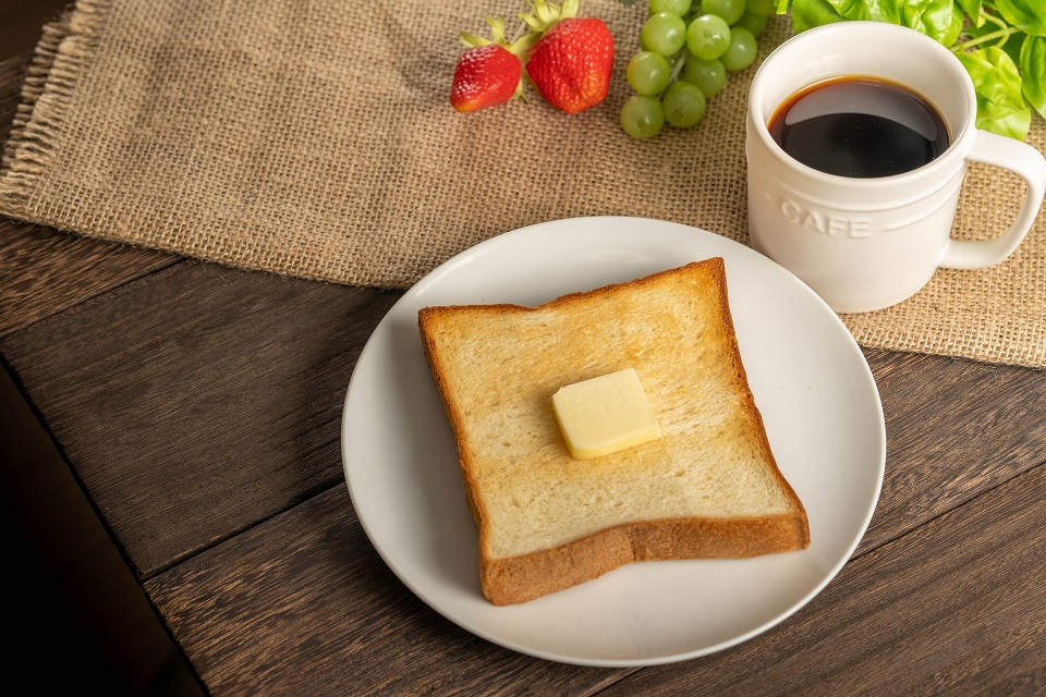 バターをのせたトーストとコーヒーの朝食風景（グルテンフリー米粉パンのイメージ）