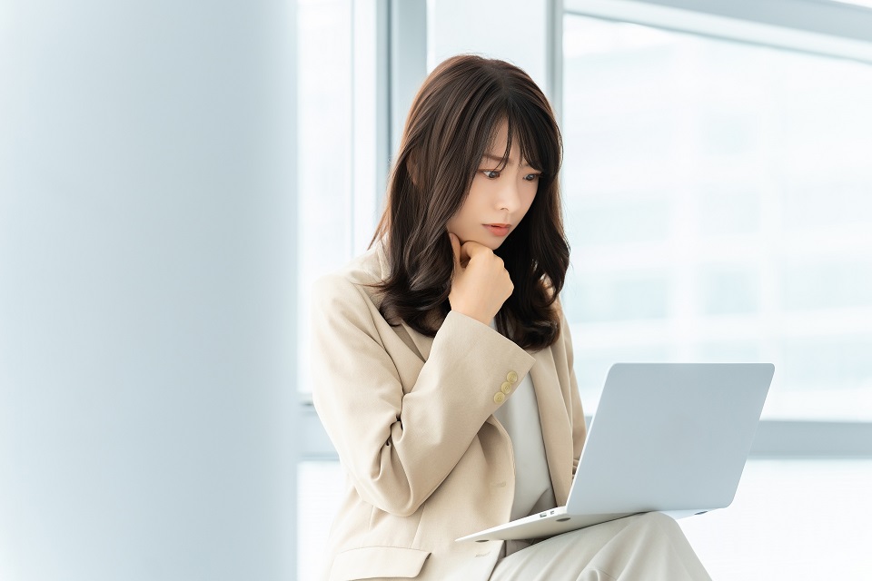 宅建試験2026の合格点予想についてノートパソコンを見ながら考える女性